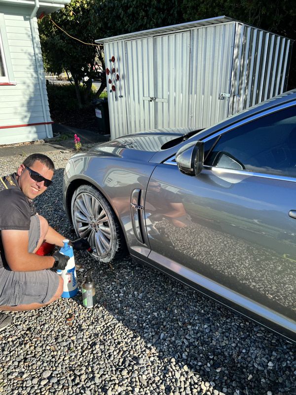 Aaron cleaning a vehicle wheel at a client's home