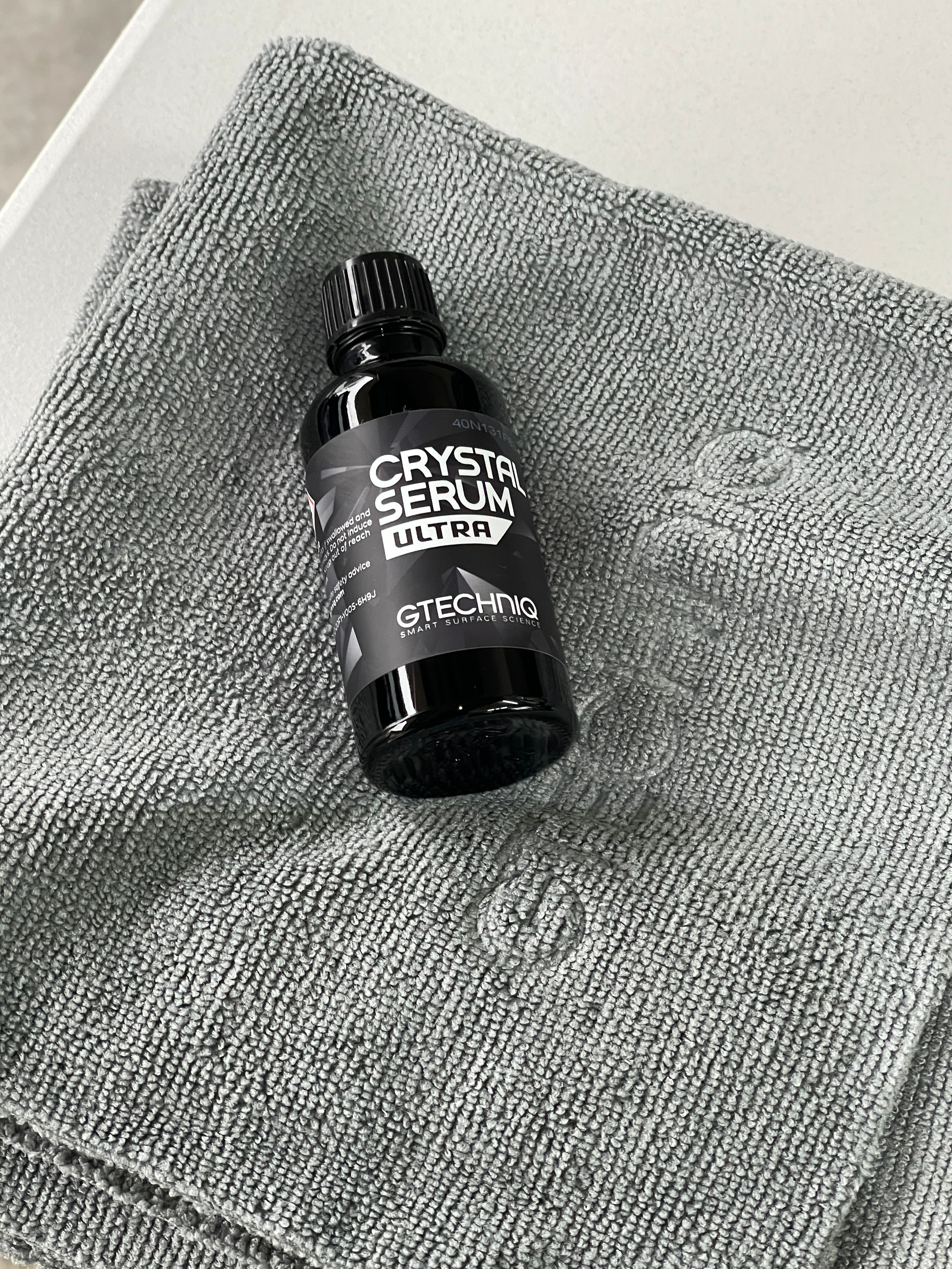 Gtechniq Crystal Serum Ultra ceramic coating bottle on microfiber cloth, showing professional grade 9-year protection product