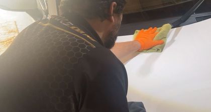 Machine polishing a panel under inspection lighting before coating