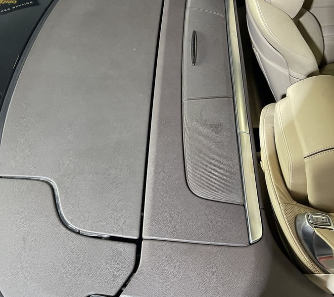 Interior plastic trim before restoration, showing fading and surface degradation