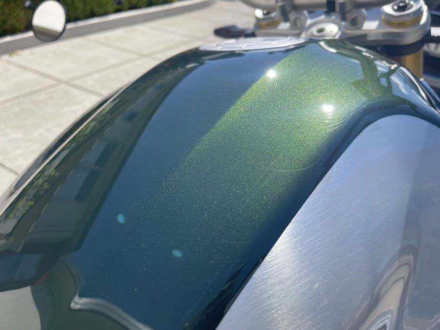 Scratches and marking visible across a paint surface in direct light