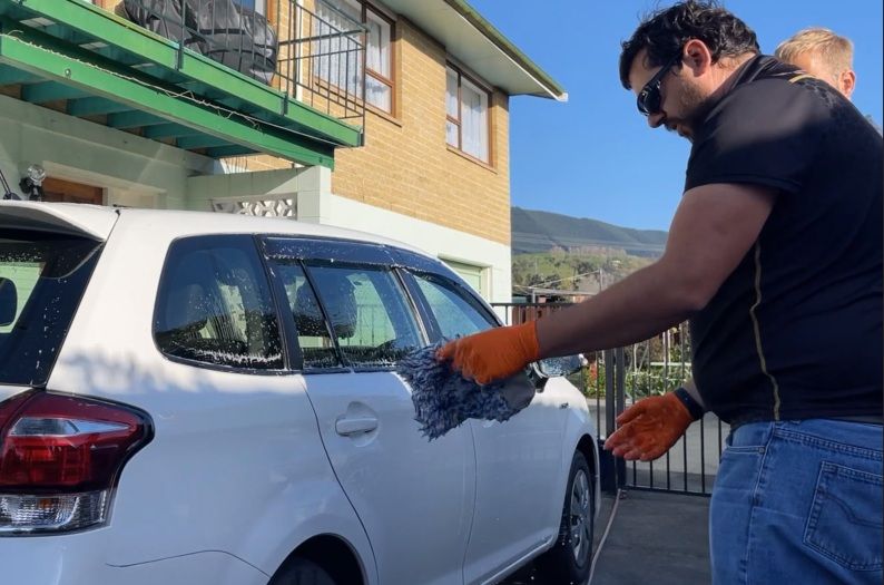 Aaron demonstrating proper ceramic coating washing techniques to a client using correct mitt handling